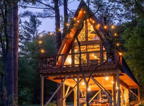 Designer A-Frame Treehouse with hot tub on river