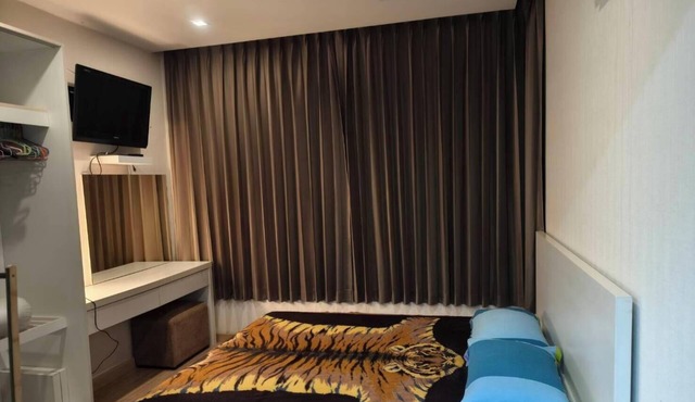 Fully furnished 1-bedroom condo with two air conditioning units in room.